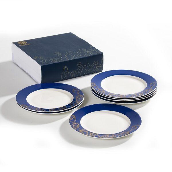 alt="Bread and dessert plates with golden faces and figures on navy background"