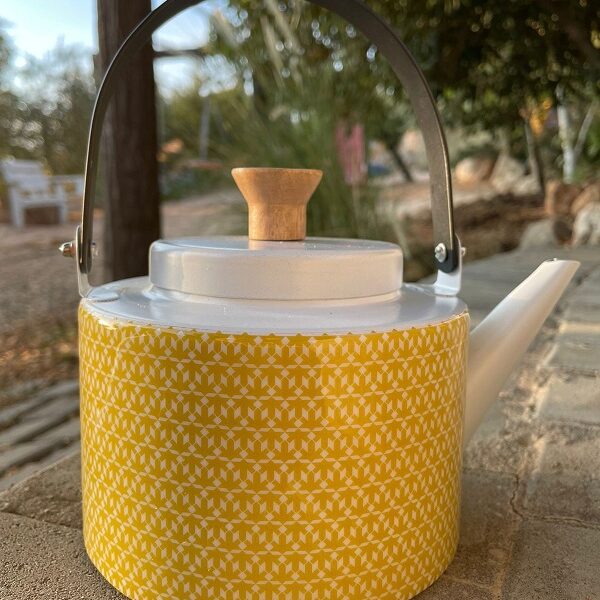 alt="yellow tea pot with designs"