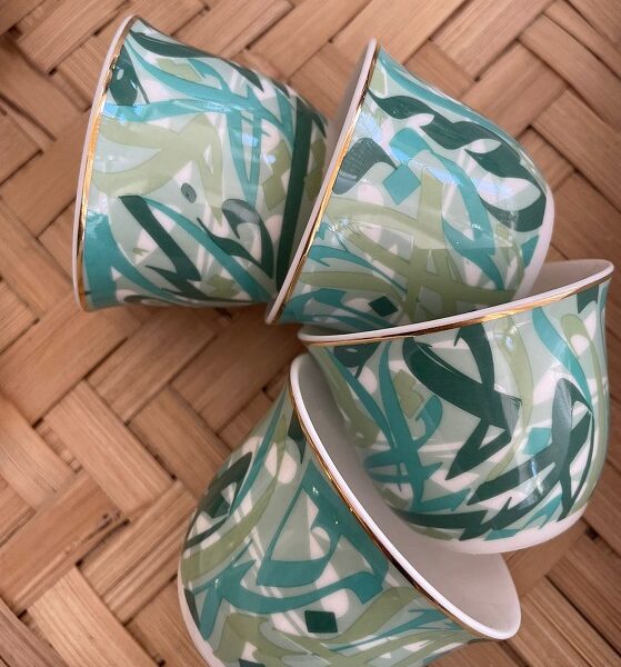 alt="porcelain arabic coffee cups with arabic calligraphy in green"